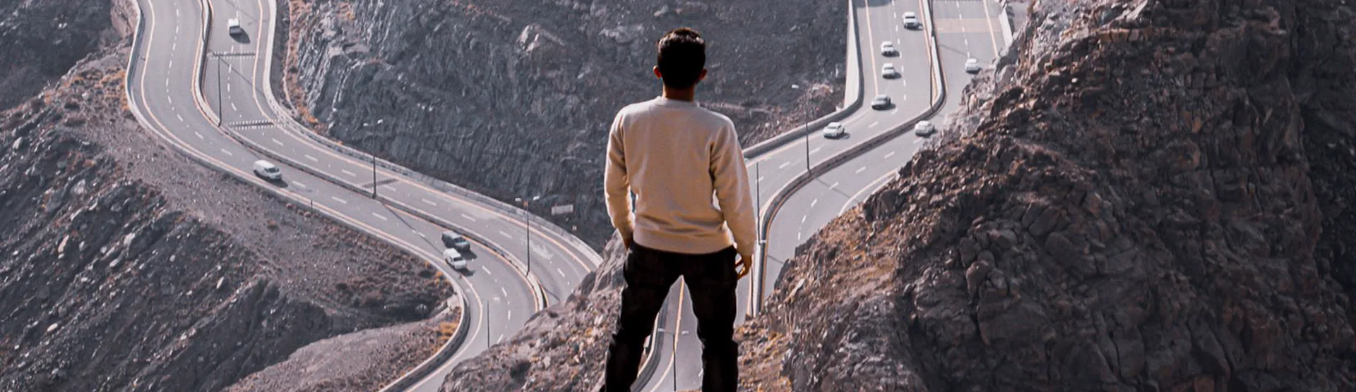 A man overlooking winding mountain roads