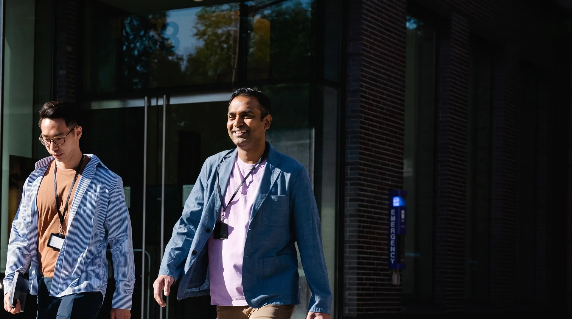 Two colleagues walking out of an office building together